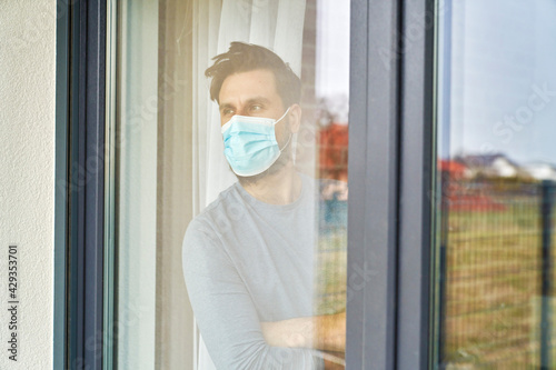 Man on quarantine looking through the window