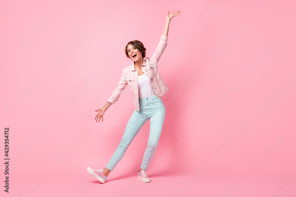 Full length photo portrait of charming girl performing trick isolated on pastel pink colored background Full length photo portrait of charming girl performing trick isolated on pastel pink colored background