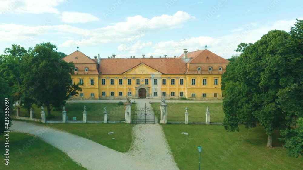 Castle from old medieval surrounded by forests and a river. Toursim Vacation to a historical Palace. Old fashioned building fort. Noble building in the nature. Aerial view with zoom in, 4K 