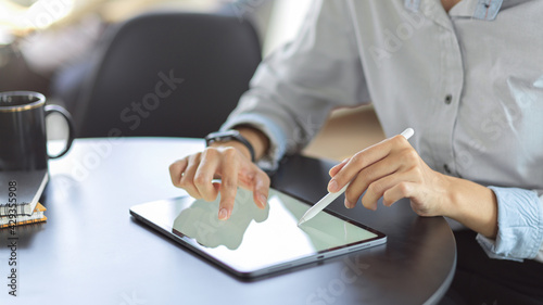 Close up view of young female using mock up blank screen digital tablet