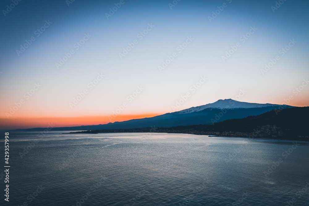 Calm scenery of Mt Etna and the sea during sunset . Copy space, post card, background 
