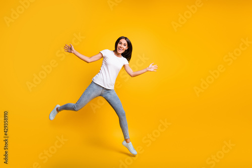 Fototapeta Naklejka Na Ścianę i Meble -  Full size photo of cute lovely young woman jump raise hands good mood isolated on yellow color background