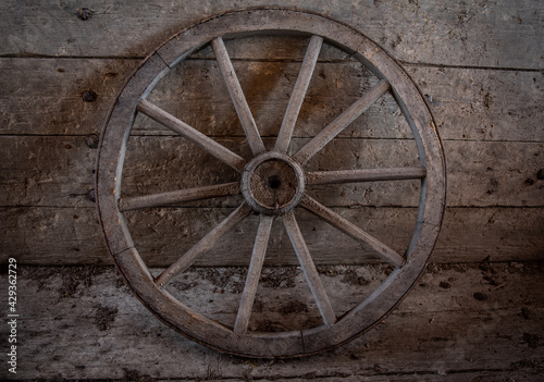 Old vintage cartwheel against wooden wall