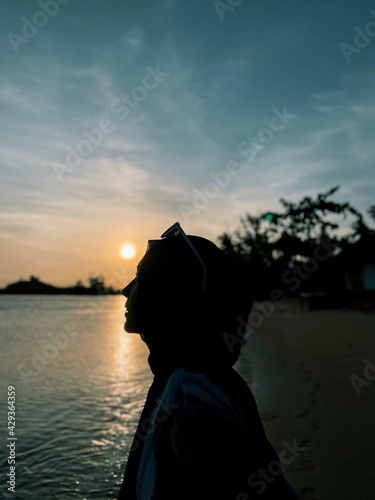 A Beautiful Woman Smiling in front of Sunset at Beach