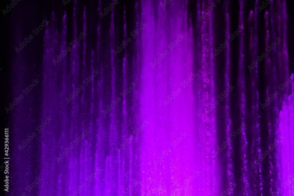 Splashing fountain in purple color at night Splashing fountain in purple color at night