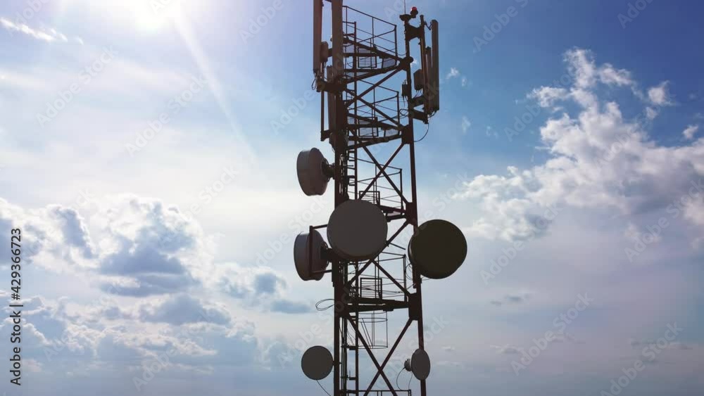 Aerial drone view around of the telecommunication tower. Animated visualization of mobile network signals originating from a cell tower. 5g cellular mobile wave signal transmission.