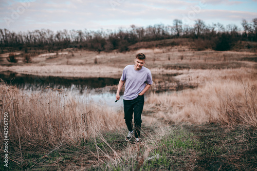 the guy stands near a small lake and looks into the distance