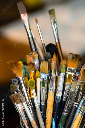 Set Collection Art Paint Brushes In Cup On Artist's Desktop. Artistic Equipment In Studio
