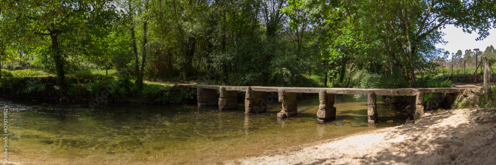 Panoramic view of an old stone footbridge over the Neiva River in Antas, Esposende, Portugal. Panoramic view of an old stone footbridge over the Neiva River in Antas, Esposende, Portugal.