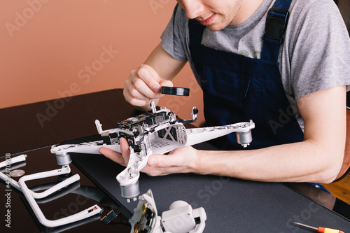 Close-up Of Person's Hand Repairing Drone Using Screwdriver. a man working in a repair shop