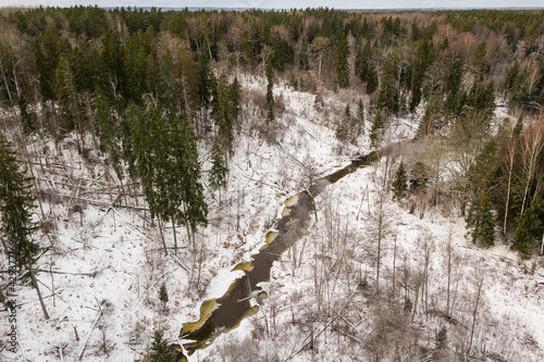 Aerial view of winding river and forest in Riezupe river nature park in winter day, Latvia.  photo