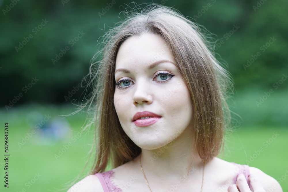 Naklejka premium Portrait of a young beautiful girl in the park
