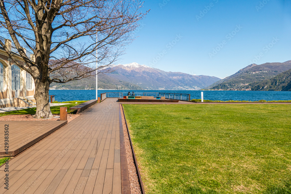 Luino viewpoint on Lake Maggiore with two tourists sitting on a bench