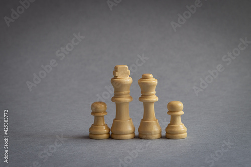 Collection of white chess pieces in close-up on gray isolated background  copy space