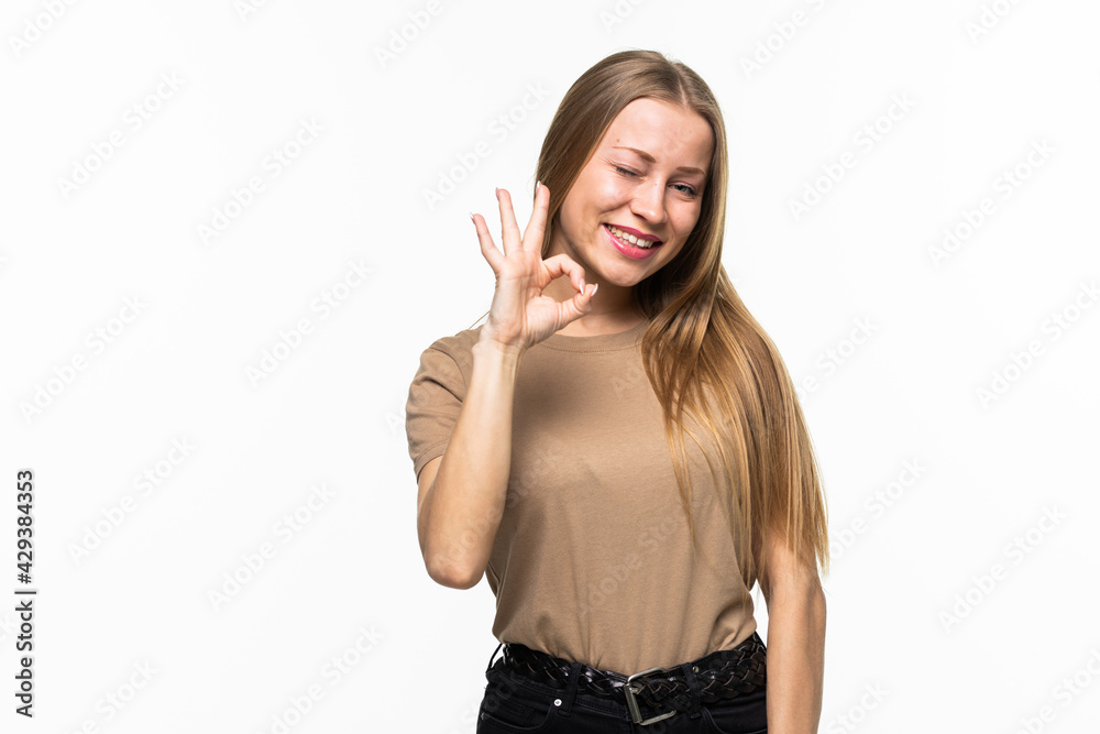 Young female with OK gesture winking isolated on white background Young female with OK gesture winking isolated on white background