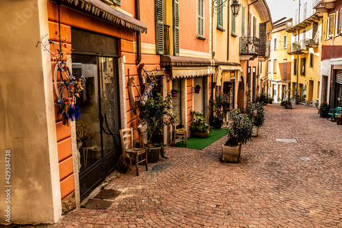 Beautiful street in the historic center of Luino with shops, plants and flowers © Alessio
