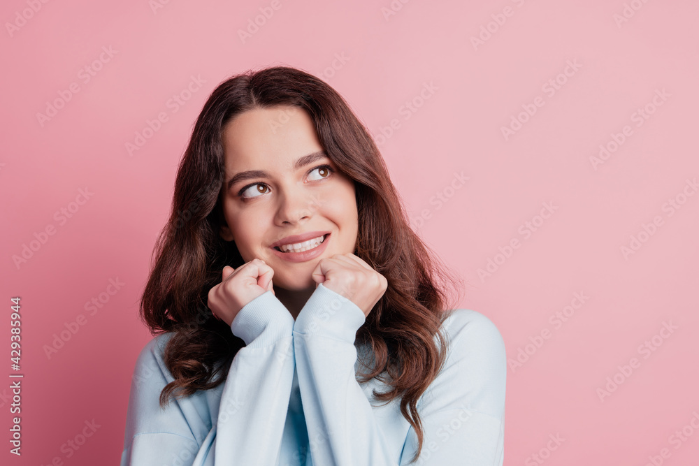 Dreamy adorable fists cheeks look side empty space on pink wall Dreamy adorable fists cheeks look side empty space on pink wall