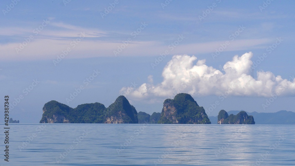 Exotic scenery islands with cloudscape and calm waters of Andaman sea in Krabi Province, Thailand.