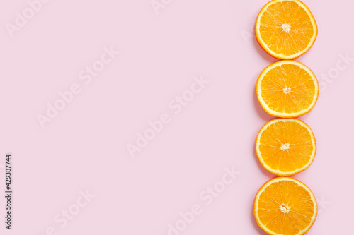 Orange slices border on pink background with copy space. Empty place for inspirational text and products. Flatlay, top view.