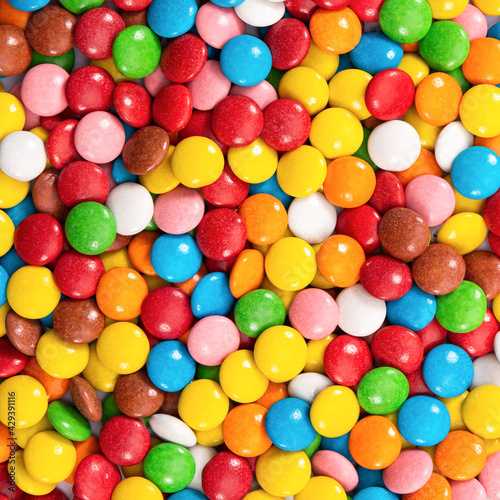 Colorful small chocolate dragee. Multicolored button-shaped candies as background.