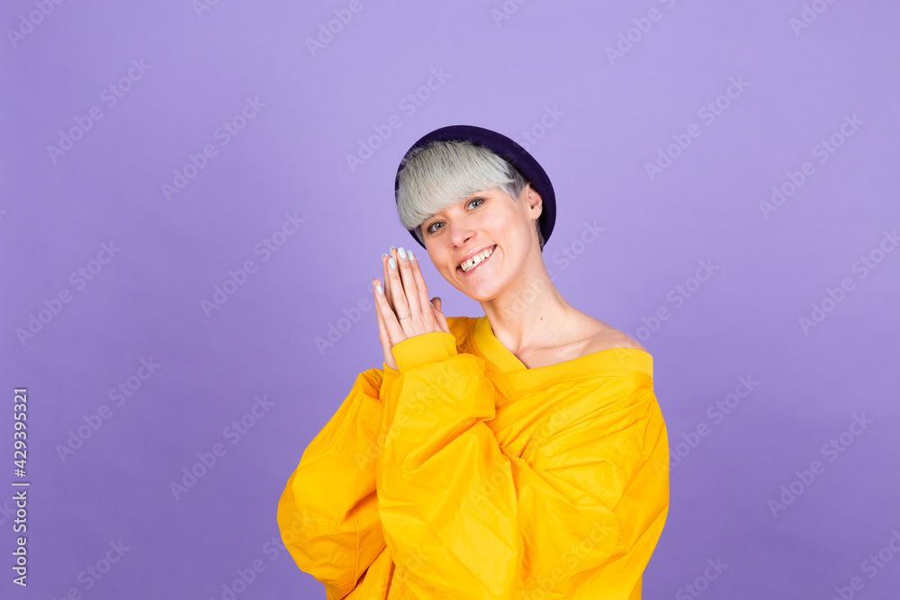 Stylish european woman on purple background happy sweet smile hands together
