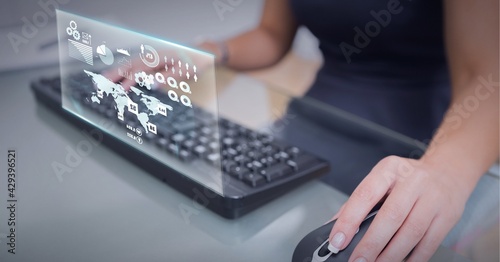 Composition of world map and digital icons on screen over woman using mouse and computer keyboard