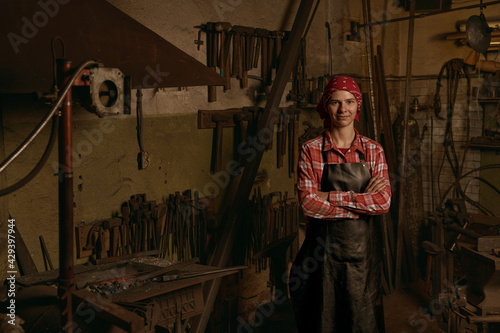 Canvas Print Female blacksmith in workshop standing confident portrait