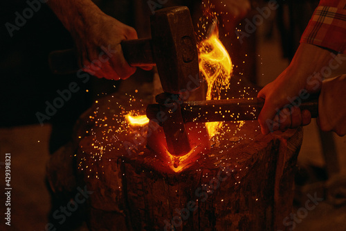 Blacksmiths hit molten metal with hammers close up Fototapeta