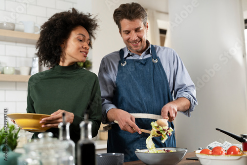 Happy smiling couple cooking together. Husband and wife preparing delicious food