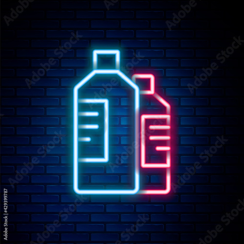 Glowing neon line Plastic bottles for laundry detergent, bleach, dishwashing liquid or another cleaning agent icon isolated on brick wall background. Colorful outline concept. Vector