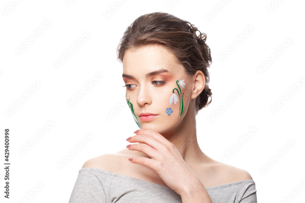 Lovely young woman with painted flowers on her face isolated on white background Lovely young woman with painted flowers on her face isolated on white background