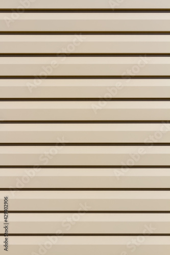 Light metallic siding panel background. Siding board backdrop in residential housing wall.