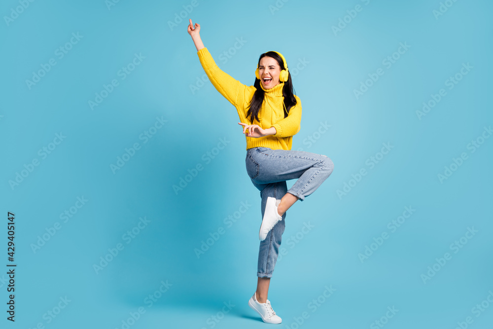 Full length bdoy size view of pretty overjoyed cheerful girl listening mp3 dancing having fun isolated over bright blue color background Full length bdoy size view of pretty overjoyed cheerful girl listening mp3 dancing having fun isolated over bright blue color background