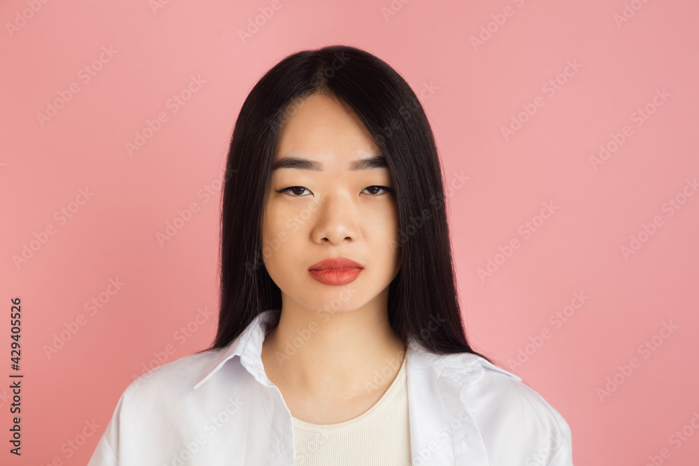 Asian young woman's portrait on pink studio background. Concept of human emotions, facial expression, youth, sales, ad. Asian young woman's portrait on pink studio background. Concept of human emotions, facial expression, youth, sales, ad.