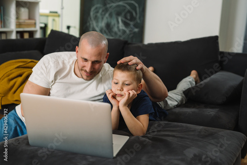 father and son using computer at home