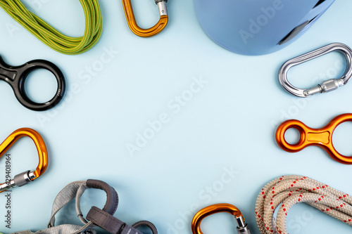 Climbing adventure equipment flat lay view. Top view of extreme mounteneering tools like helmet, carabiner, rope, gloves, radio, harness, figure eight. Concept on trendy blue background. photo