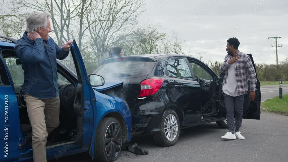 Young Couple Getting Out Of Damaged Car In Accident With Senior Driver