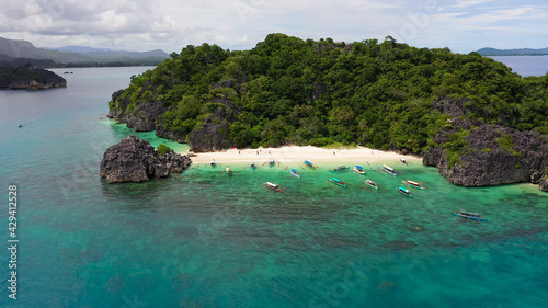 Tropical landscape: Lahos Island with beautiful beach and tourists by turquoise water view from above. Caramoan Islands, Philippines. Summer and travel vacation concept. © Alex Traveler