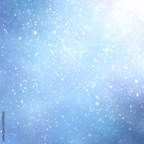 Snow flakes fly in winter sky light abstract textured background. Blurred pattern. Blue color.