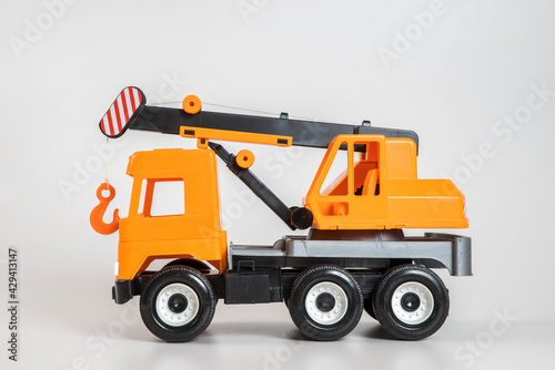 Multi-colored plastic children's toy cars on a white background. Orange crane.