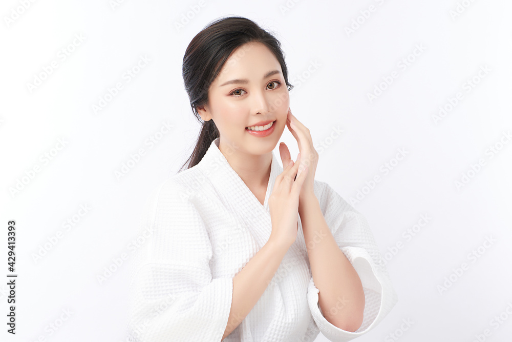 Beautiful young Asian woman wearing bathrobe on white background, Face care, Facial treatment, Cosmetology, beauty and spa Concept. Beautiful young Asian woman wearing bathrobe on white background, Face care, Facial treatment, Cosmetology, beauty and spa Concept.