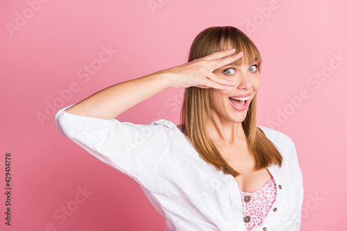 Photo of playful crazy young lady fingers cover eye excited peeking wear white blouse isolated pink color background