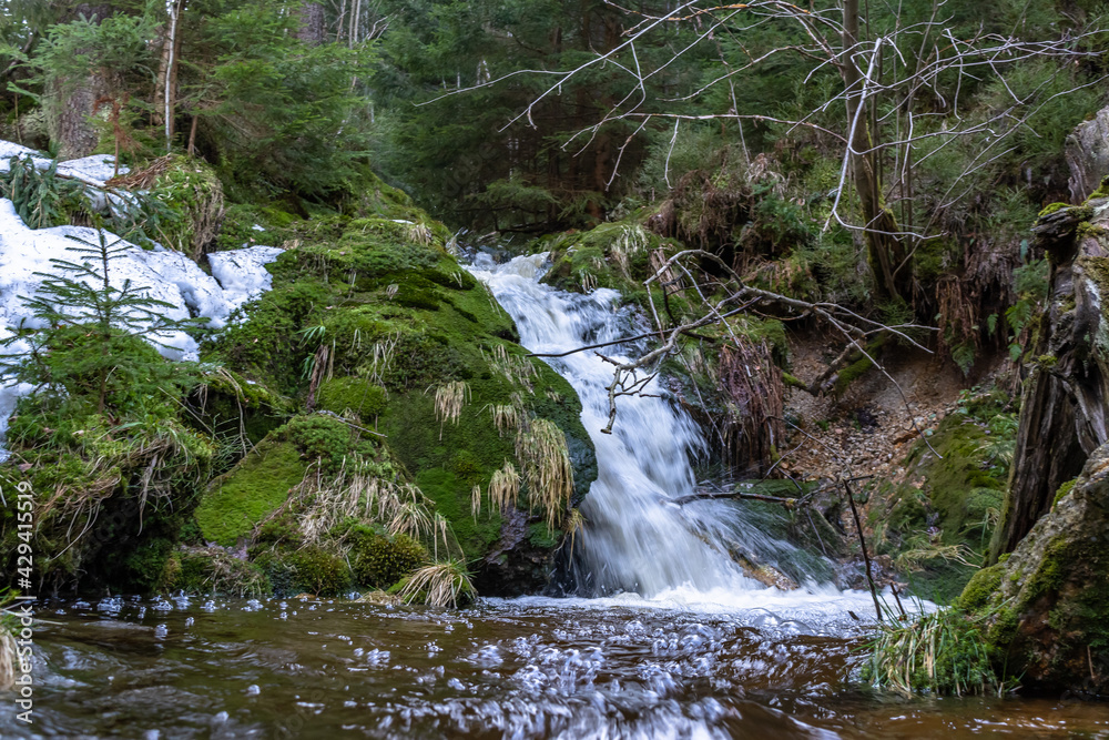 Fototapeta premium Cascade falls over mossy rocks