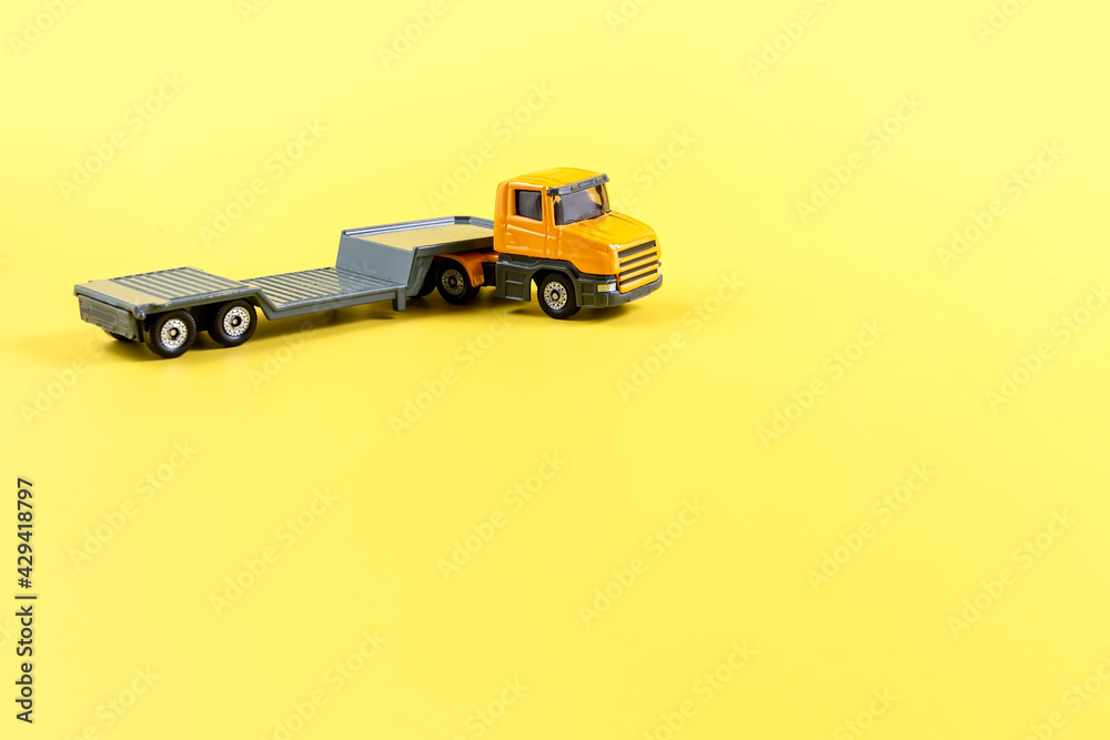 Children's toy, car on a yellow background. Car transporter, evacuator Concept. Isolate. Copy space. Children's toy, car on a yellow background. Car transporter, evacuator Concept. Isolate. Copy space.