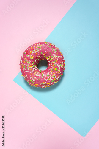 Creative food diet concept photo of donut bite on pink blue background.