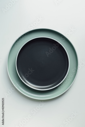 New luxury plate view from above on a isolated white background. Top view. Porcelain black and green saucer with white ring. Trendy pastel shades. Flat lay view.