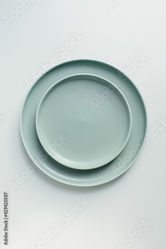 New luxury plate view from above on a isolated white background. Top view. Porcelain green saucer with white ring. Trendy pastel shades. Flat lay view.