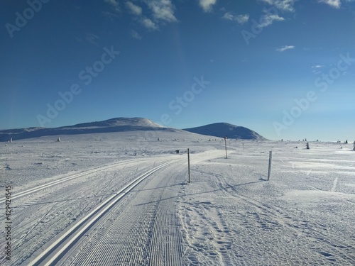 ski track in the mountains with sun and blue sky