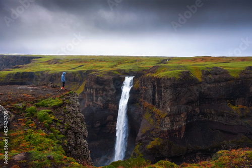 Hiker standing at the edge of the Haifoss waterfall in Iceland