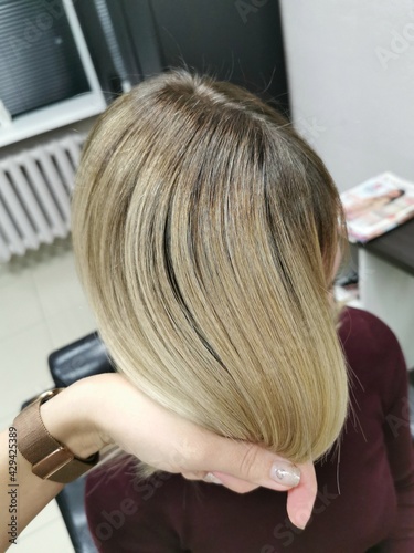 Girl with blond hair in a beauty salon. Air-touch. Embossed hair coloring.
